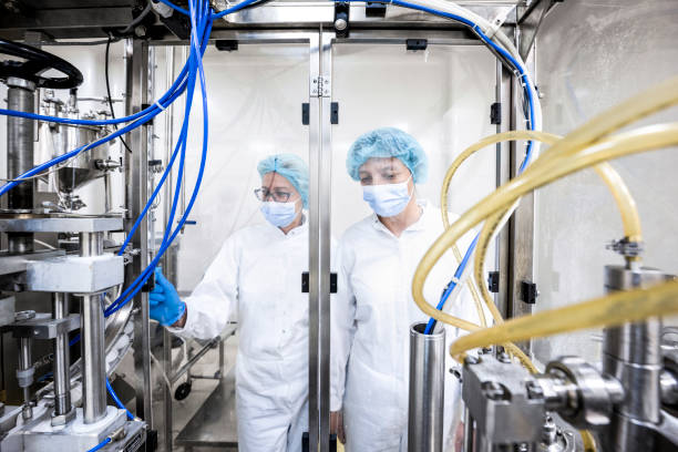 istock Two fully equipped coworkers in protective workwear seen in a pharmaceutical laboratory 1417392962
