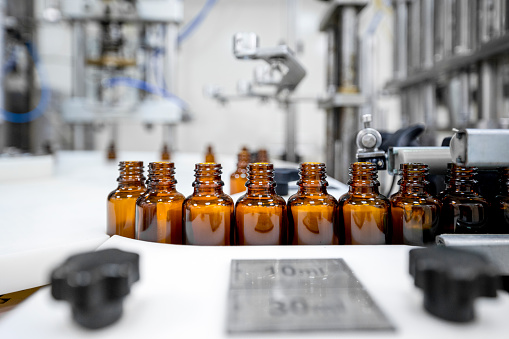 Small brown bottles seen perfectly arranged in a laboratory after production and all the proper checks during manufacturing in a pharmaceutical factory.