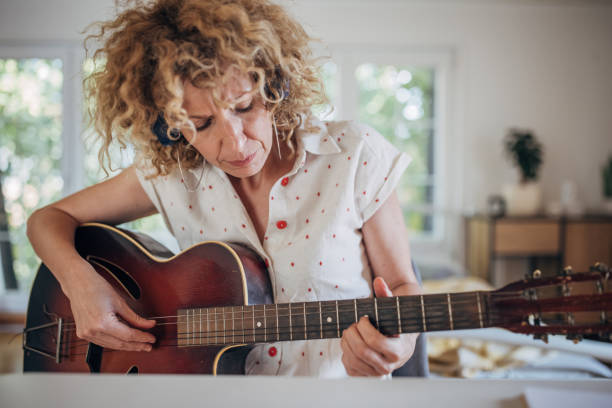 istock Woman learning to play guitar 1417394442