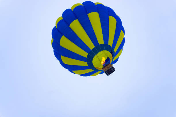 istock blue yellow hot air balloon flying into the sky 1417395312