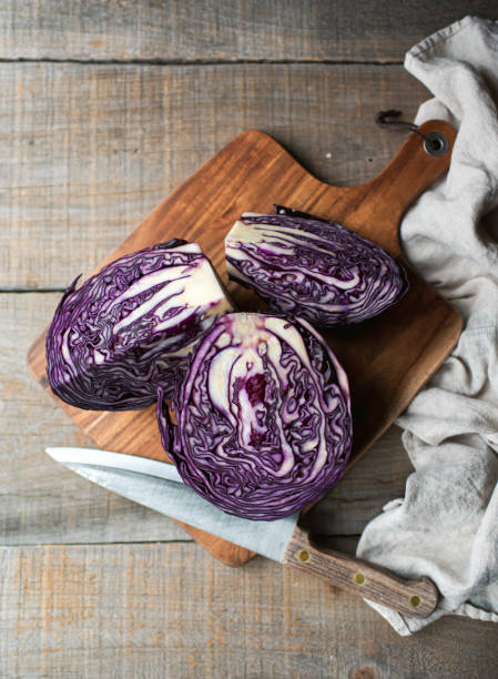 istock Overhead of sliced red cabbage on a wooden cutting board on table. 1417395863