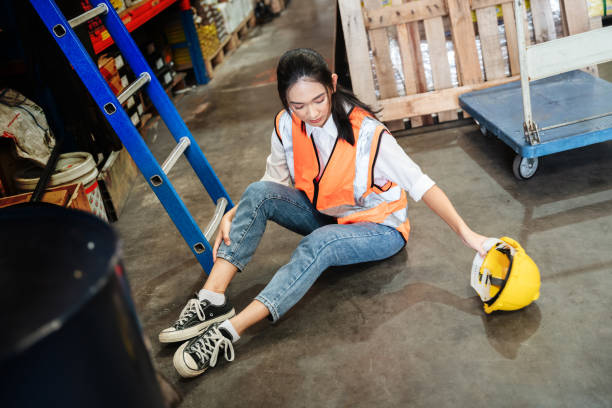 istock A female warehouse worker has an accident while working in a factory. 1417396221