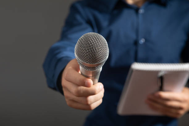 istock Caucasian journalist holding microphone, notepad and pen. 1417396309