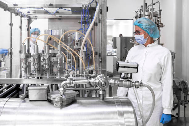 istock Pharmaceutical technician in a protective clothing equipment seen in a laboratory during a manufacturing process 1417397761