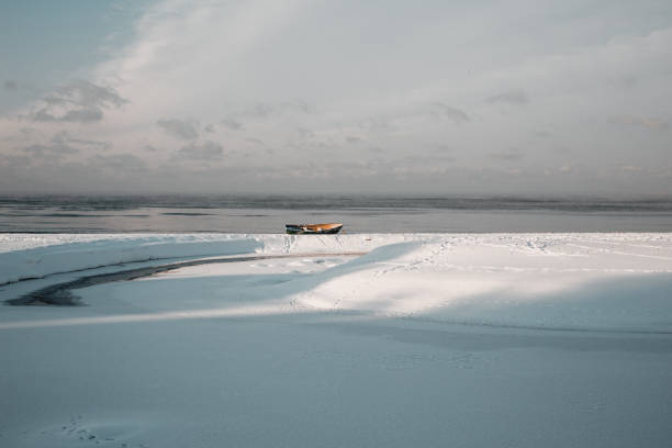 Boat surrounded by vast ocean of snow in Fort Chipewyan during the winter months