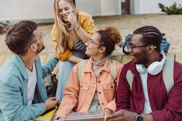 istock Hanging out on campus. Young group of students using laptop 1417404931