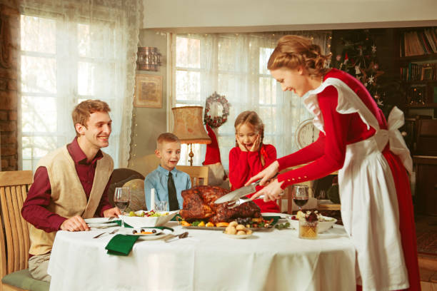семья, празднующая праздничный ужин вместе, ретро-стиль 50-х годов - stereotypical homemaker стоковые фото и изображения