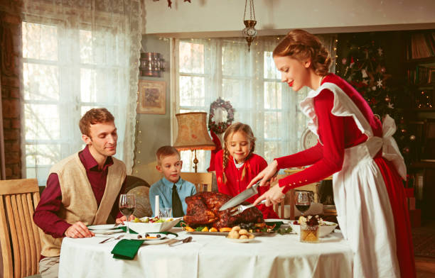 familie bei einem gemeinsamen feiertagsabendessen im retro-stil der 50er jahre - hausfrau klischee fotos stock-fotos und bilder