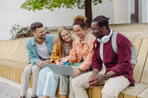 istock Hanging out on campus. Young group of students using laptop 1417404981
