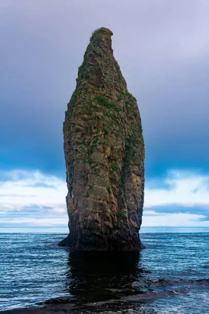 seascape of Kunashir, ocean shore with a huge vertical rock in the water