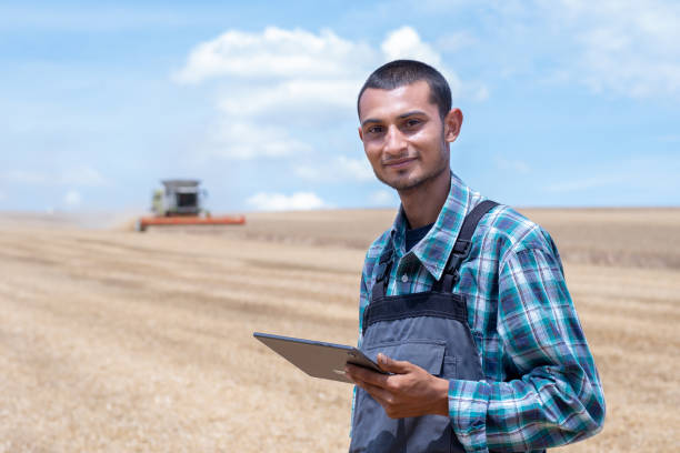 istock Young cheerful entrepreneur in wheat field during harvest 1417407552