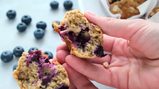 Vegan oatmeal, banana, blueberry muffin in woman hands.