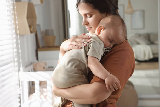 istock Happy young mother with her sleeping baby at home 1417413496