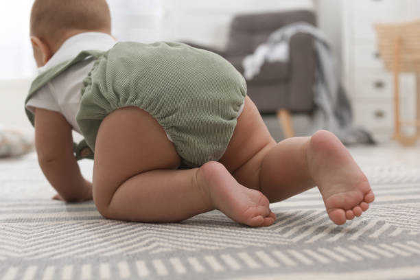 istock Cute baby crawling at home, focus on legs 1417414078