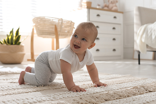 Lindo bebé gateando en el suelo en casa photo