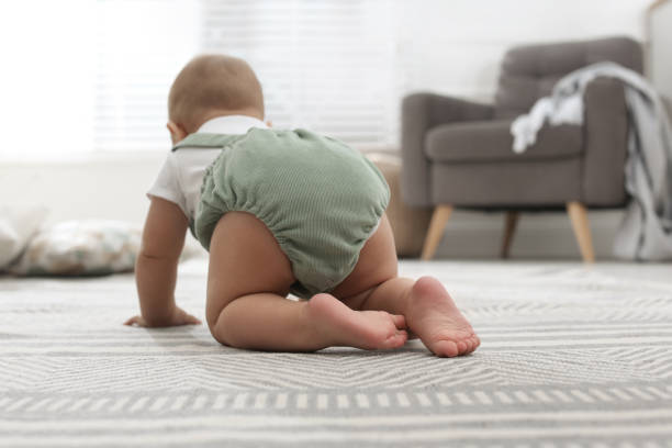 istock Cute baby crawling at home, focus on legs 1417415208