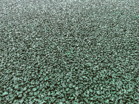 texture, background. coating for a sports field made of rubberized material in green, emerald color. anti-slip running surface.