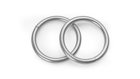 Two crossed silver colored crossed metallic rings. Steel rings isolated on white background, clipping path included