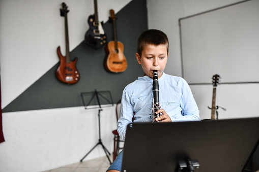 Focused Boy Playing Clarinet In Classroom