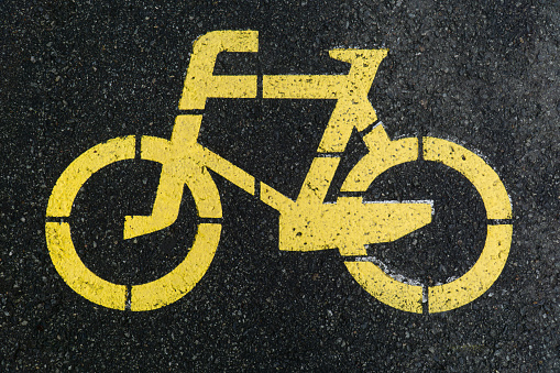yellow road markings on wet asphalt bike path