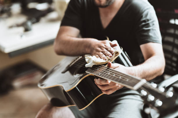 Expert Guitarist Cleaning Instrument After Playing