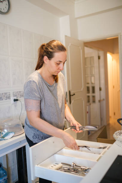 istock Woman putting cutlery in drawer 1417424184