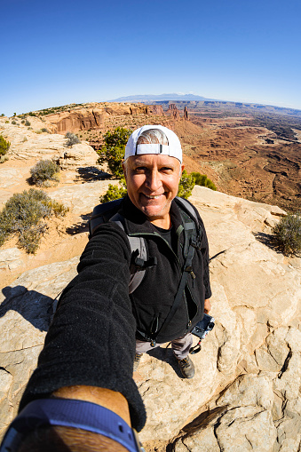 Handsome middle age man enjoying the natural beauty of the Sky Mesa in Canyonlands National Park.