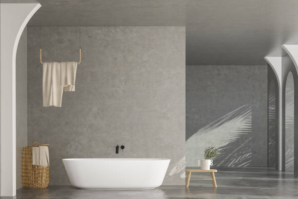 istock Bright bathroom interior with concrete floor and wall, white bathtub and two sinks 1417433801
