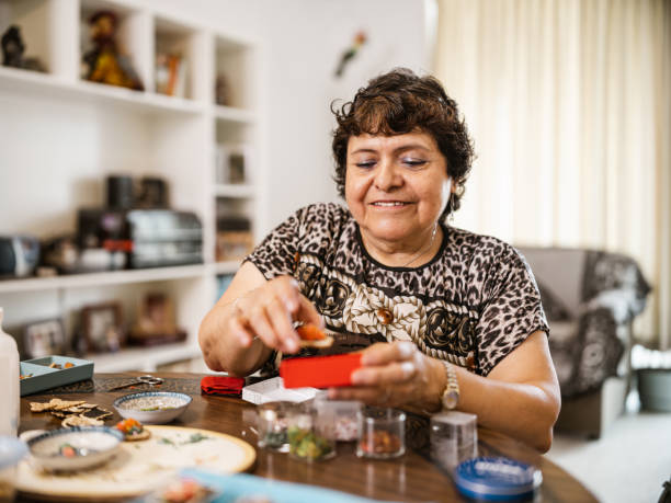 Senior disabled Latin woman doing arts and craft stock photo