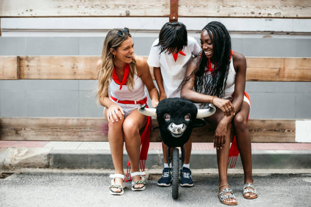 un garçon et deux jeunes filles d’origine caucasienne et afro-américaine s’amusent pendant la course des taureaux avec un taureau jouet.concept de diversité et de tolérance - clothing traditional culture chinese culture black photos et images de collection