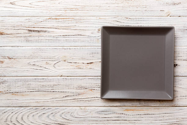 istock Top view of empty square plate on wooden background. Empty space for your design 1417442374