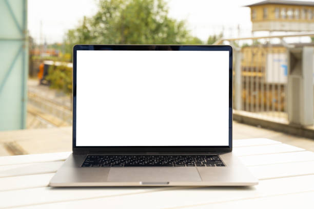 istock Laptop with white screen in business office or shopping mall. Empty copy space, blank screen mockup. Soft focus laptop with interor background. Travel, study and office work concept. 1417443387