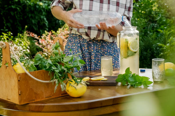 istock Young woman making summer refreshing lemonade in back yard garden. 1417443654