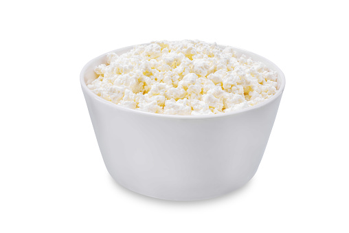 Cottage cheese in a bowl on a white isolated background. toning. selective focus
