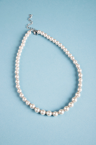 White pearl necklace on blue background