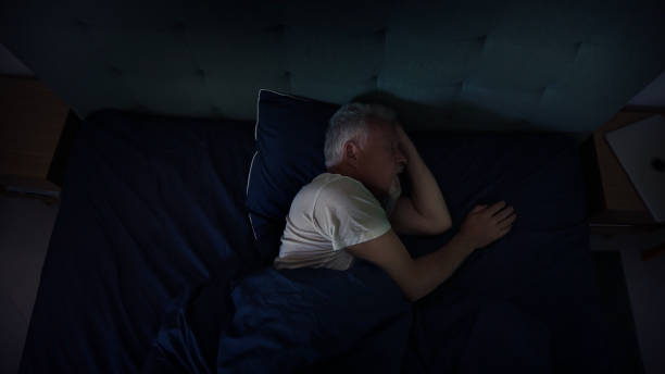 istock Mature man relaxing in comfortable bed. Smiling and feeling cozy afetr fighting insomnia 1417450553