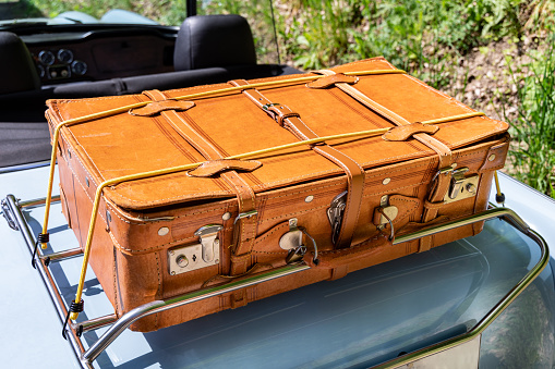 Selective focus on pile of three vintage, old and warn travel suitcases or trunks on the floor. Retro style voyage.