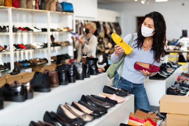 istock Focused Asian woman in a protective mask chooses moccasins 1417457590