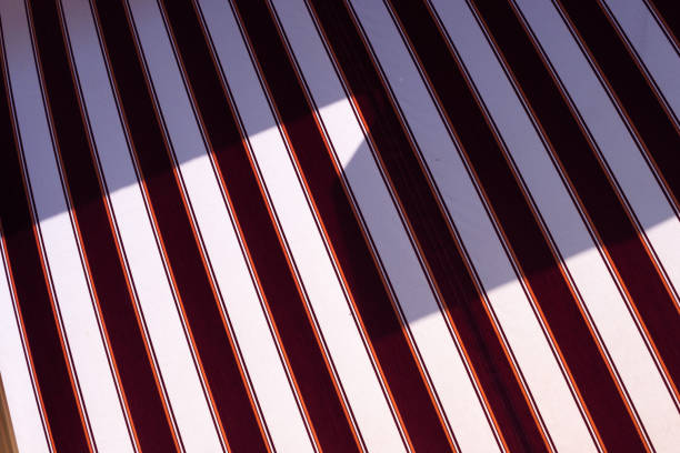 Red and white diagonal striped background, repeat stripes on fabric, minimal graphic lines pattern on textile.