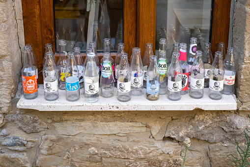 Gökçeada, Çanakkale, Turkey, August 17,2022: Different soda bottles in front of the window in Gökçeada İsland