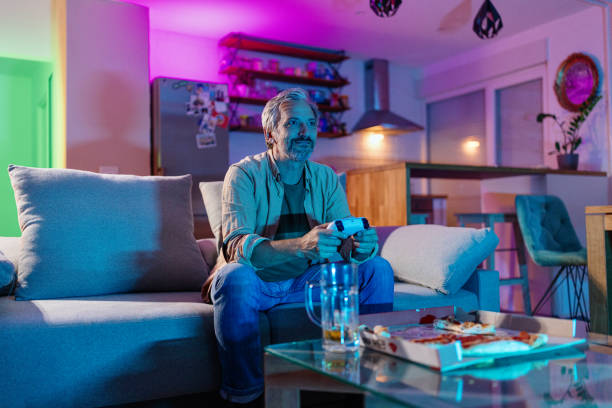 istock Mature man playing video games at home 1417468124