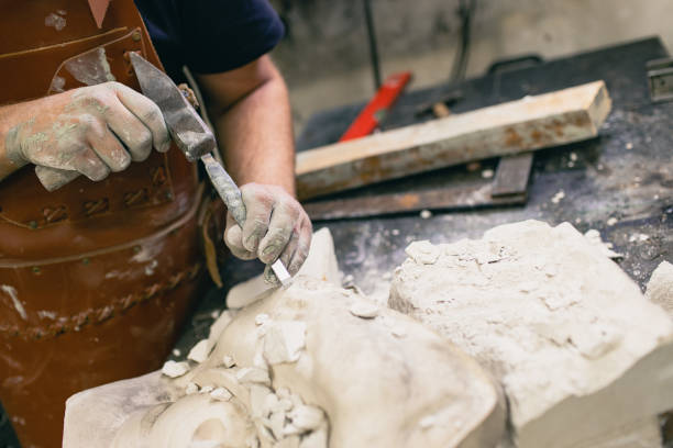 istock Man sculptor creates sculpt bust gypsum human woman sculpture. Statue craft creation workshop 1417469578