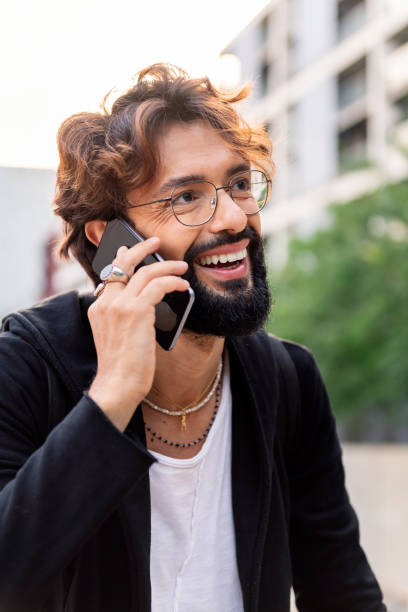 istock young man smiling happy talking on mobile phone 1417470193