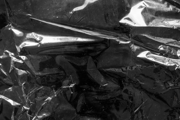 istock transparent plastic bag film wrap overlay texture on black background 1417470502