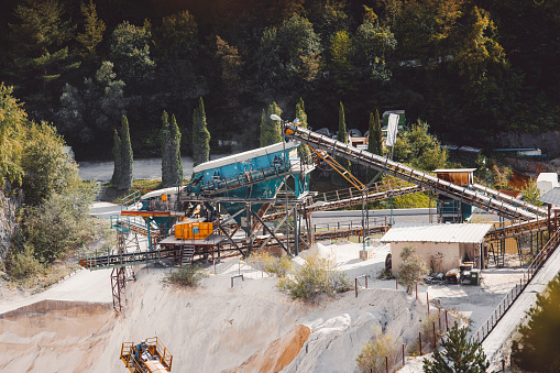 Several moving conveyor belts moving gravel in the quarry.