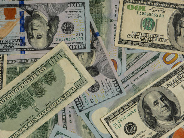 istock Large pile of hundred dollar bills in background view. 1417471193