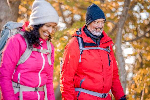 istock Smiling pair enjoying walk in autumn forest 1417474180