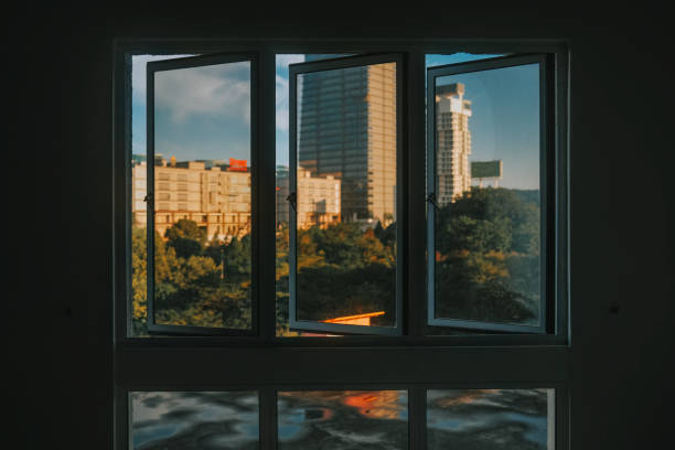 istock Sunrise looking through window at city with reflection on window with after rain 1417477785