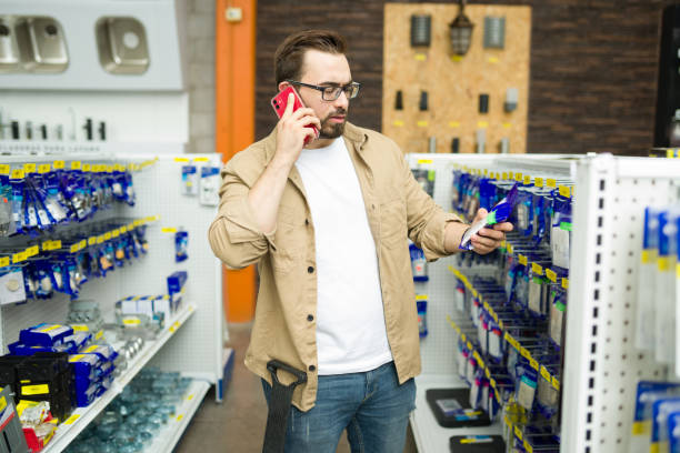 istock Indecisive man asking for help on the phone while shipping at the hardware store 1417478961