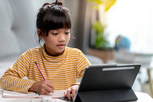 Kid self isolation using tablet for his homework,Child doing using digital tablet searching information on internet during covid 19 lock down,Home schooling,Social Distance,E-learning online education autoaislamiento del niño usando la tableta para su tarea,niño haciendo uso de la tableta digital buscando información en internet durante el bloqueo de covid 19,educación en el hogar,distancia social,educación en línea de aprendizaje electrónico